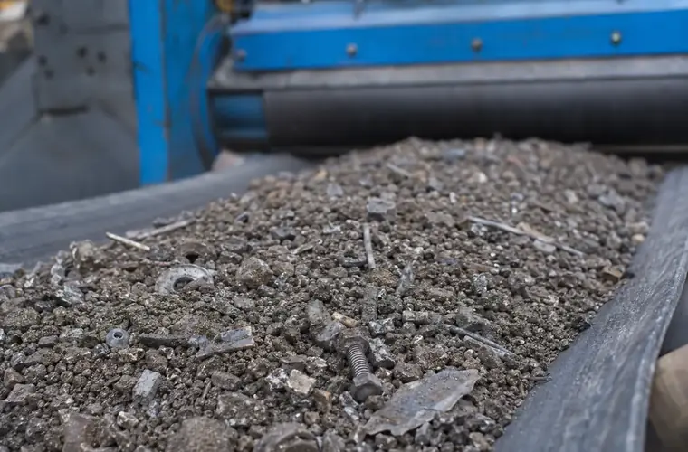 Matériau transporté sous un séparateur magnétique